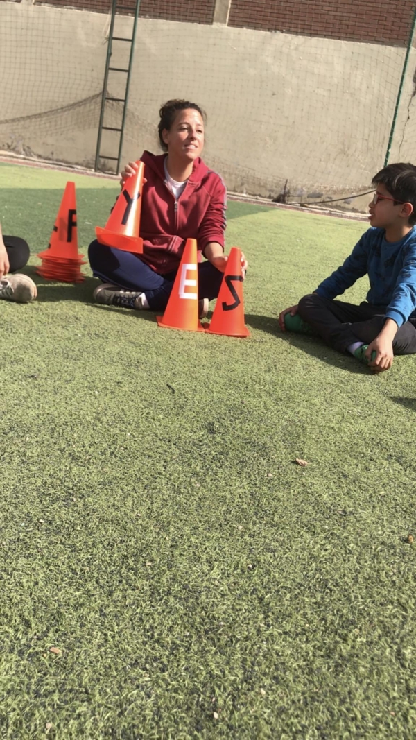 Teaching Letter Names, Letter Sounds, Words, and Word Actions in English on the Pitch